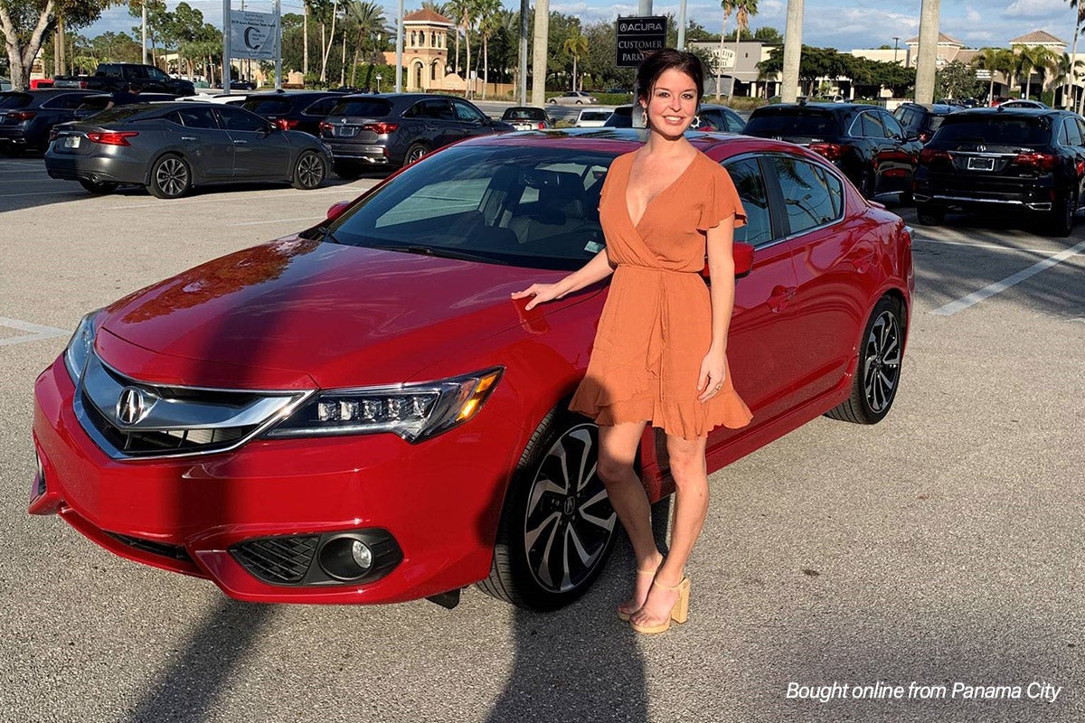 Woman standing in from of her new red Acura